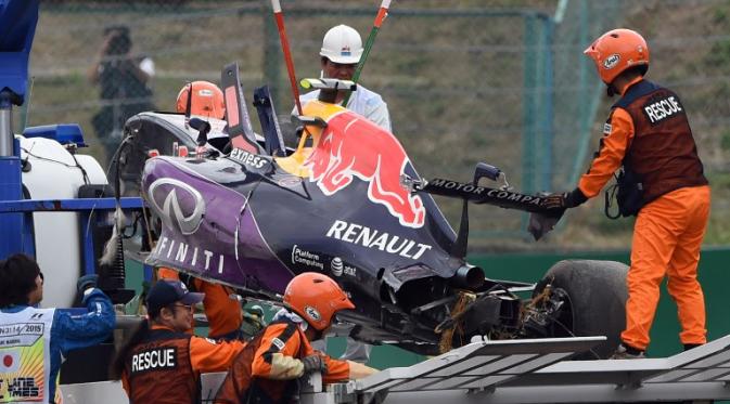 Jet darat Daniil Kvyat dievakuasi menggunakan crane setelah mengalami crash di beberapa menit terakhir sesi kualifikasi GP Jepang yang berlangsung di Sirkuit Suzuka, Sabtu (26/9/2015) sore WIB.(AFP Photo/Toshifumi Kitamura)