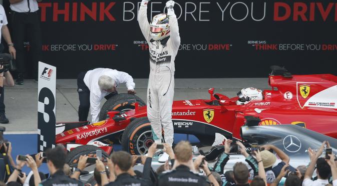 Pebalap Mercedes Lewis Hamilton melakukan selebrasi usai memenangkan Formula 1 GP Jepang di Sirkuit Suzuka, Minggu (27/9/2015). (Liputan6.com/REUTERS/Toru Hanai)