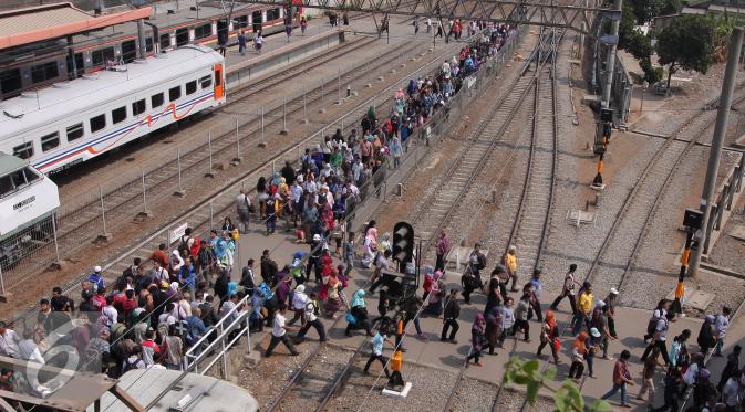 Ratusan pekerja menyebrangi rel kereta di stasiun Tanah Abang, Jakarta, Selasa (29/9/2015). Kemenaker mencatat PHK per Agustus 2015 meningkat 62% yaitu sekitar 26.506 orang. (Liputan6.com/Angga Yuniar)