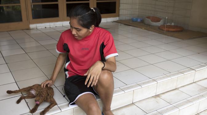 Pebulutangkis ganda putri, Nitya Krishinda bermain bersama anjing peliharaannya saat berada di Pelatnas Cipayung, Jakarta, Senin (28/9/2015). (Bola.com/Vitalis Yogi Trisna)