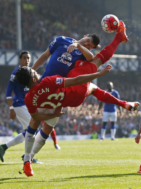 Pemain Liverpool Emre Can berebut bola dengan pemain Everton Gareth Barry dalam lanjutan Liga Premier Inggris di Goodison Park, Minggu (04/10/2015). Liverpool dan Everton bermain imbang 1-1. (Action Images via Reuters / Lee Smith)