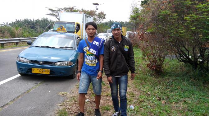 Dua Bobotoh (Persib Bandung) memutuskan berjalan-jalan di pinggir Tol Kopo, Soreang, Bandung, karena bus mereka terjebak kemacetan, Sabtu (10/10/2015). (Liputan6.com/Antonius Hermanto)