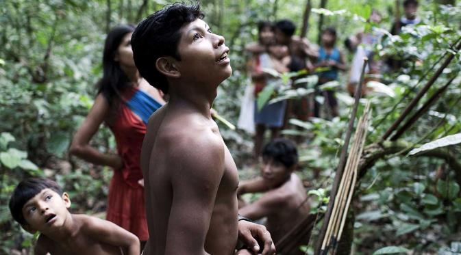 Sorang pemuda dari suku Awa sedang mengamati sesuatu (survivalinternational.org)