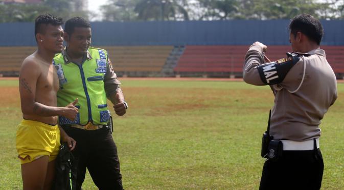 Polisi pun menggunakan kesempatan berfoto dengan Ferdinand Sinaga seusai latihan Sriwijaya FC. Bukti nyata begitu populernya sang pemain di mata pencinta sepak bola nasional. (Bola.com/Nicklas Hanoatubun)