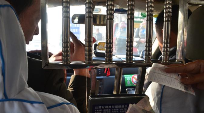 Berikan kertas yang memuat tempat tujuan dalam bahasa Mandarin pada supir taksi, Cina. | via: live-less-ordinary.com