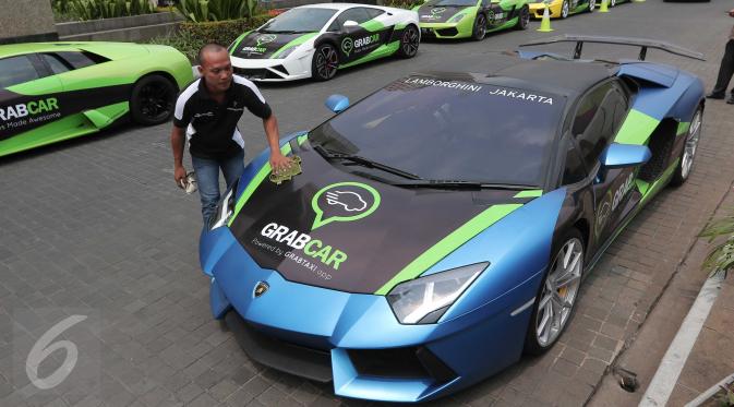Pengemudi membersihkan supercar Lamborghini yang diluncurkan Grabcar, layanan pesan kendaraan berbasis aplikasi di Jakarta, Rabu (21/10). Layanan ini dapat dinikmati secara gratis melalui  aplikasi Grabtaxi.  (Liputan6.com/Angga Yuniar)