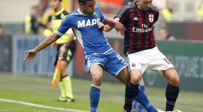 Ricardo Montolivo berduel dengan Defrel di duel Milan vs Sassuolo (Liputan6.com/REUTERS/Alessandro Garofalo)