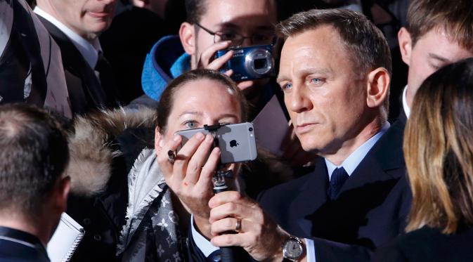 Aktor Daniel Craig berselfie dengan penggemarnya saat menghadiri premiere film terbarunya James Bond 007 