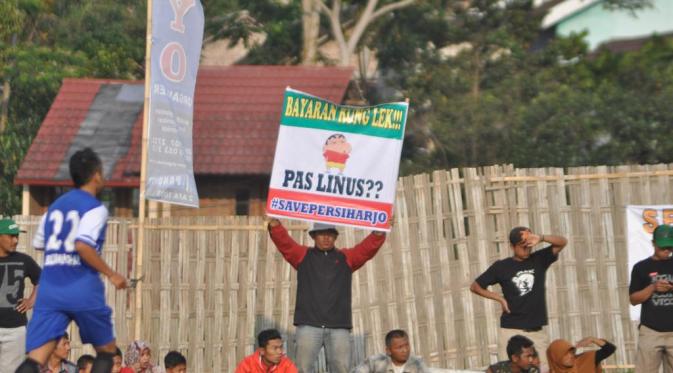 Salah satu suporter Persiharjo Sukoharjo membentangkan spanduk yang berisi penagihan gaji pemain saat Liga Nusantara pada turnamen Piala Bupati Karanganyar di Stadion Mini Plumbon, Tawangmangu, Sabtu (31/10/2015). (Bola.com/Romi Syahputra)