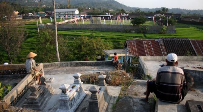 Pemandangan Stadion Mini Plumbon dari 'tribune' penonton dadakan alias kuburan. Warga menikmati laga Piala Bupati Karanganyar dari kuburan secara gratis. (Bola.com/Romi Syahputra)
