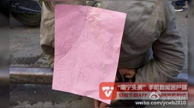 Tulisan di belakang wanita bertuliskan, aku seorang pencuri daging babi dan domba. (Shanghaiist)
