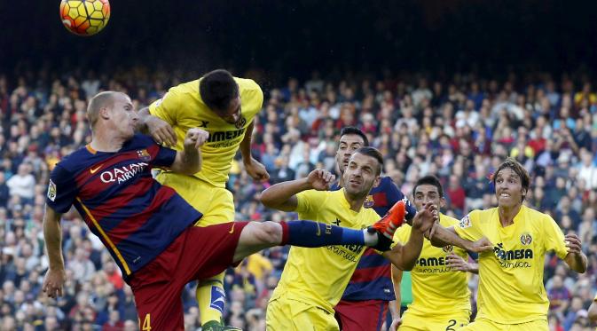Pemain Barcelona Jeremy Mathieu (kiri) berebut bola dengan para pemain Villarreal  pada lanjutan La Liga Spanyol di Stadion Camp Nou, Barcelona, Spanyol, MInggu (8/11/2015). (REUTERS/Albert Gea)