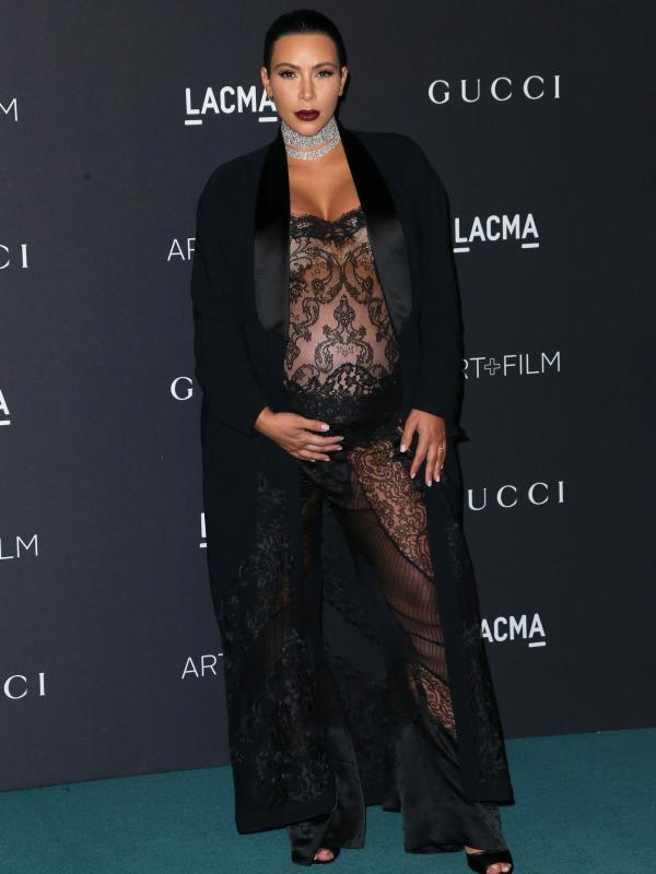 Kim Kardashian berpose saat menghadiri ajang LACMA 2015 Art+Film Gala di Los Angeles , California , Sabtu (7/11). Selain atasan yang menampilkan perut membesar, Kim memadukannya jaket tuksedo bergaya maskulin. (Frederick M. Brown / Getty Images / AFP)