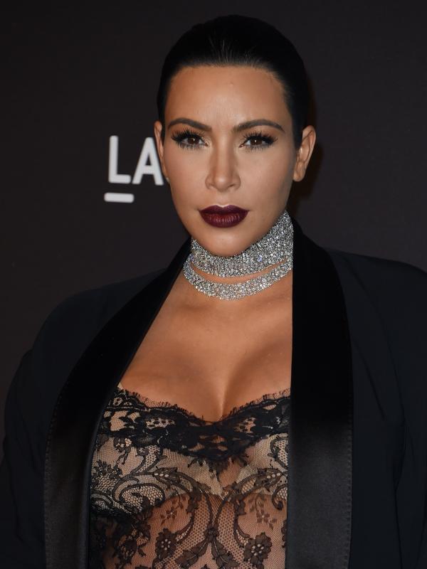 Sosialita dan bintang reality TV, Kim Kardashian mengaplikasikan lisptik dark berry yang terkesan misterius saat menghadiri ajang LACMA 2015 Art+Film Gala di Los Angeles , California , Sabtu (7/11). (AFP PHOTO / MARK RALSTON)