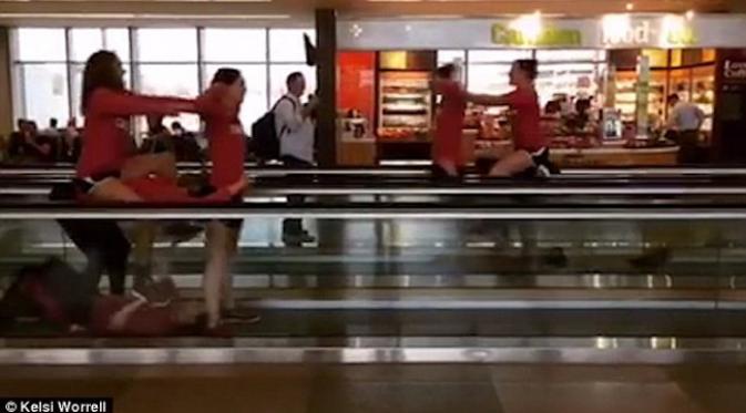 Dalam memanfaatkan waktu menunggu, tim renang berlatih di walkway bandara. (foto: Facebook/Kelsi Worrell)