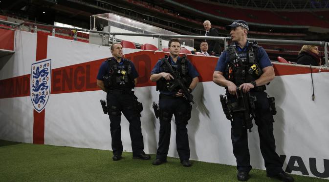 Kepolisian Inggris dengan senjata lengkap menjaga pertandingan timnas Prancis melawan Inggris di Stadion Wembley. (AFP Photo/Adrian Dennis)