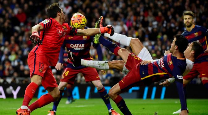 Kiper Barcelona, Claudio Bravo, berusaha mengamankan gawangnya dari gangguan pemain Real Madrid, Cristiano Ronaldo, dalam laga La Liga Spanyol di Stadion Santiago Bernabeu, Madrid, Minggu (22/11/2015) dini hari WIB. (AFP Photo/Pierre-Philippe Marcou)