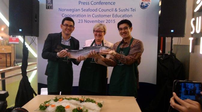 (Dari kiri ke kanan) Regional Director Norwegian Seafood Council Jon Erik Steenslod, Menteri Perikanan Norwegia Elisabeth Asparker, dan Direktur Sushi Tei Sonny Kurniawan memegang ikan salmon dari Norwegia di Jakarta, Senin (23/11/2015).