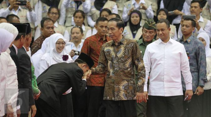 Seorang guru mencium tangan Presiden Joko Widodo (Jokowi) saat hadir dalam Peringatan Hari Guru Nasional 2015, Istora Senayan, Jakarta, Selasa (24/11). Peringatan hari guru tahun ini mengangkat tema 'Guru Mulia Karena Karya'. (Liputan6.com/Faizal Fanani)