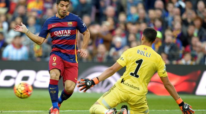Striker Barcelona, Luis Suarez, saat melepaskan tendangan yang berujung gol ke gawang Real Sociedad, pada laga lanjutan La Liga, di Stadion Camp Nou, Sabtu (28/11/2015). (AFP/Lluis Gene)