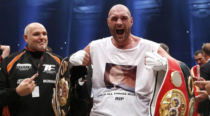 Tyson Fury memamerkan sabuk juara yang baru saja diraihnya usai mengalahkan Wladimir Klitsckho