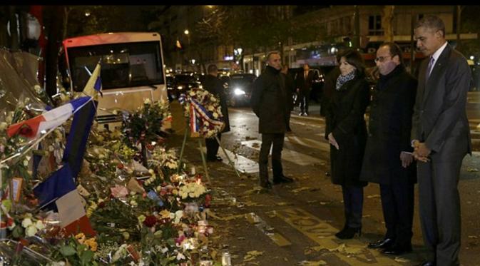 Obama mendoakan korban teror Paris di Teater Bataclan setelah meletakkan setangkan mawar putih. (Reuters)