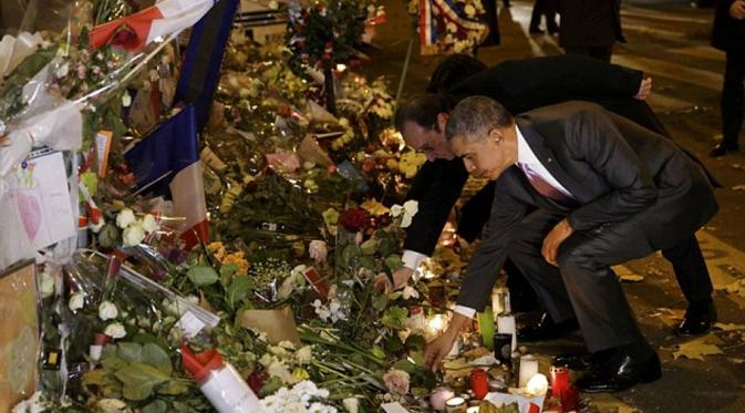 Obama meletakkan setangkai mawar putih untuk korban teror Paris di Teater Bataclan. (Reuters)
