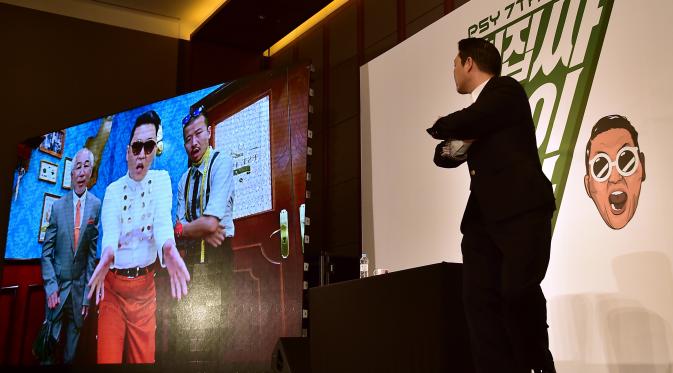 Psy menunjukkan video klip barunya saat konferensi pers untuk mempromosikan album ketujuhnya di sebuah hotel di Seoul (30/11). Sebelumnya Psy telah sukses dengan hitsnya “Gangnam Style“, “Gentleman” dan “Hangover“. (AFP PHOTO/ JUNG YEON-JE)