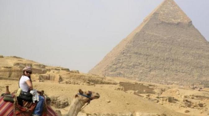 Turis berfoto di depan piramida di Mesir (Reuters)