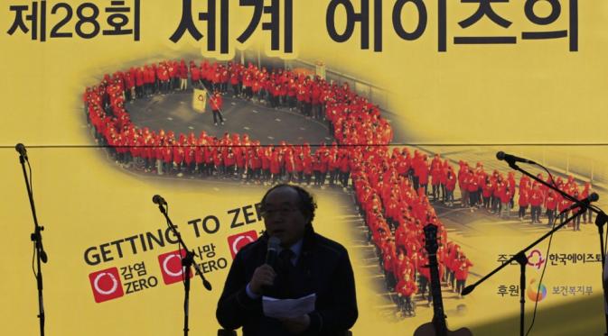 Partsipan berpidato tentang AIDS di depan pita merah pada peringatan Hari AIDS Sedunia, Seoul, Korea Selatan, Selasa (1/12). | via: Lee Jin-man/AP Photo