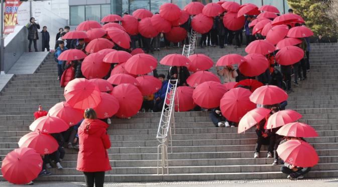 Murid di sekola menengah membuat formasi pita merah menggunakan payung di Hari AIDS Sedunia, Seoul, Korea Selatan, Selasa (1/12). | via: Lee Jin-man/ AP Photo