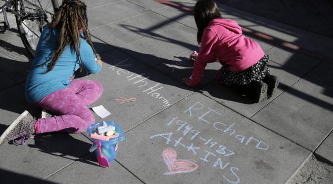 Murid sekolah dasar menulis nama pengidap HIV yang meninggal di Hari AIDS Sedunia, San Fransisco, California, Selasa (1/12). | via: Eric Risberg/AP Photo
