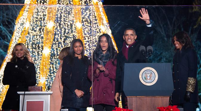Presiden AS Barack Obama (kedua kanan) melambaikan tangan ke ribuan warga saat akan menyalakan Pohon Natal Nasional di Taman Ellipse, dekat Gedung Putih, Washington, Kamis (3/12). Acara tersebut menandai dimulainya musim Natal. (AFP PHOTO/JIM WATSON)
