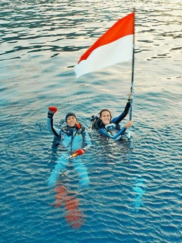 Bersama Nadine Chandrawinata, Marshall Sastra mengibarkan sang mera mutih di permukaan laut. (Instagram @marshallsastra)