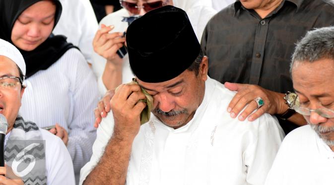 Gubernur Banten, Rano Karno mengusap air mata saat pemakaman ibunya, Lily Soekarno M Noor di TPU Tanah Kusir Jakarta, Senin (7/12/2015). Ibunda Rano Karno wafat di usia 77 tahun akibat komplikasi penyakit. (Liputan6.com/Helmi Fithriansyah)