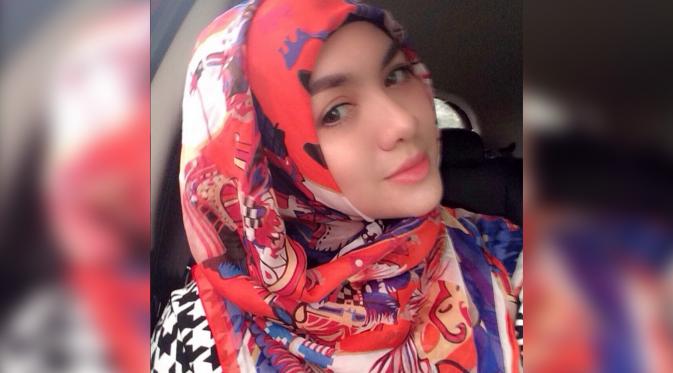 Vicky Shu tampil anggun dan menawan saat mengenakan hijab bermotif abstrak dengan warna dominan merah. (Instagram.com/Vickyshu)