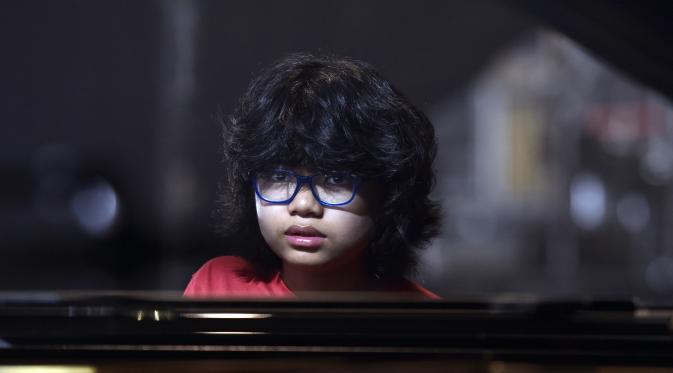 Pianis belia asal Indonesia, Joey Alexander saat latihan bermain piano di Prancis, 10 Agustus 2015. Pianis jazz berusia 12 tahun itu masuk nominasi Grammy Awards 2016.  (AFP PHOTO/PASCAL Pavani)