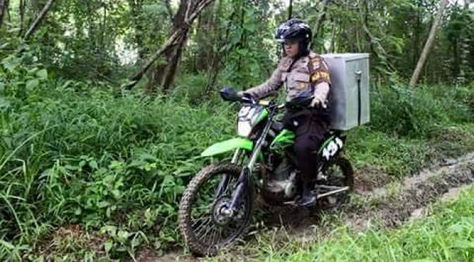 Demi membawa kotak suara, polwan rela mengendarai motor trail. | via: Krishna Murti/Facebook