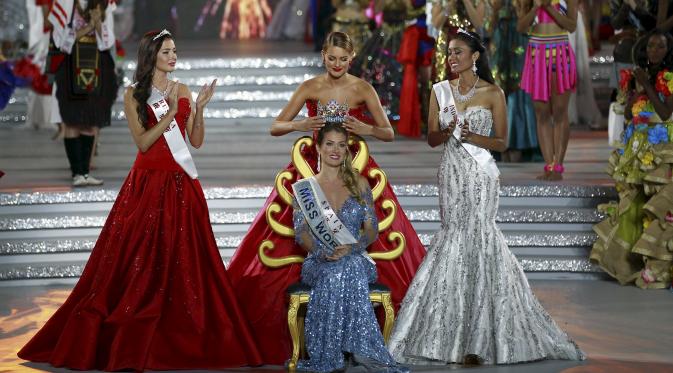 Miss Spanyol, Mireia Lalaguna Royo (duduk) menerima mahkota dari pemenang Miss World 2014 didampingi oleh juara kedua Miss Rusia, Sofia Nikitchuk dan Miss Indonesia,Maria Harfanti (kanan) di Sanya,  Cina, Sabtu (19/12). (REUTERS/Stringer)