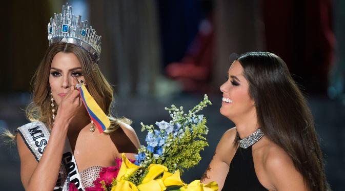 Ekspresi Miss Kolombia, Ariadna Gutierrez saat mahkota dikepalanya akan dicopot oleh Miss Universe 2014 Paulina Vega akibat kesalahan fatal MC yang salah menyebut pemenang Miss Universe 2015 di The AXIS Las Vegas, Minggu (20/12). (AFP PHOTO/Valerie Macon)