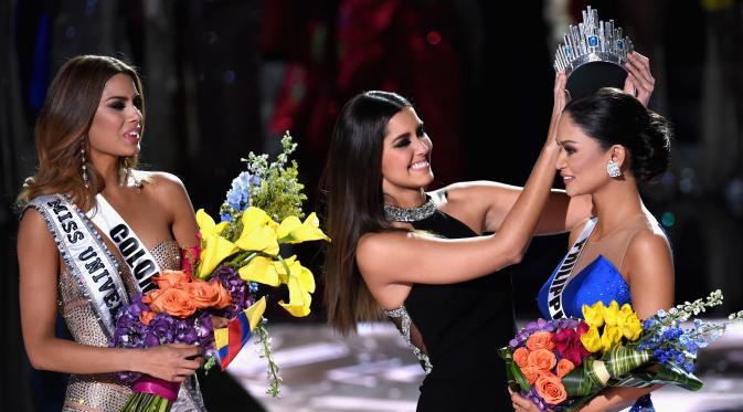 Miss Kolombia, Ariadna Gutierrez menyaksikan Miss Universe 2014 Paulina Vega menyematkan mahkota ke Miss Filipina, Pia Alonzo Wurtzbac yang dinobatkan sebagai Miss Universe 2015 di The AXIS Las Vegas, Minggu (20/12). (Ethan Miller/Getty Images/AFP)