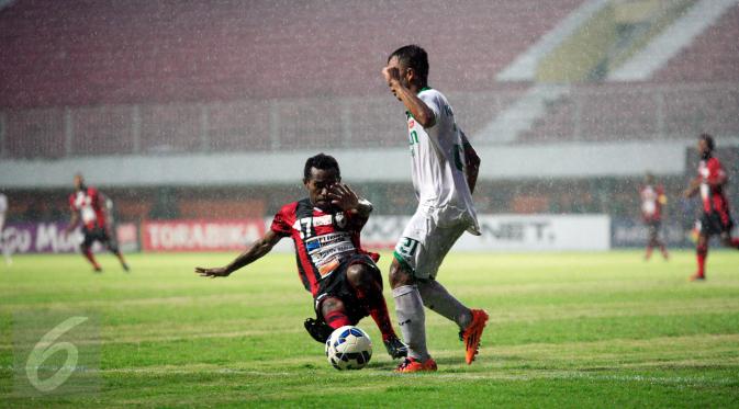 Pemain Persipura Ferinando Pahabol (bawah) berusaha mengambil bola dari pemain Surabaya United, M.Faturahman saat laga 8 besar Piala Jenderal Sudirman di Stadion Maguwoharjo, Sleman, Selasa (22/12/2015). Persipura menang 2-0. (Foto: Boy Harjanto)