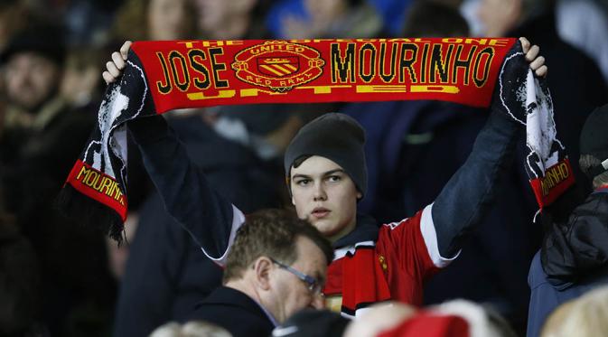  Fan Manchester United membentangkan syal bertuliskan nama Jose Mourinho. (Reuters)