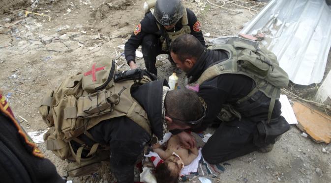 Pasukan Irak membantu evakuasi anak yang sakit dari Ramadi (Reuters)