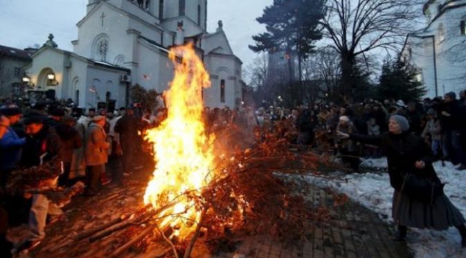 Umat Kristen Ortodoks di Serbia menari dipinggiran ranting yang di bakar dalam menyambut Natal (sumber. Bbc.com) 