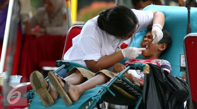 Dokter saat mengobati pasien sakit gigi di RS Bhayangkara Brimob, Depok, Jawa Barat, Sabtu (9/1/2016). Rayakan HUT ke-21, Indosiar gelar acara pengobatan gratis dan operasi katarak di 21 titik. (Liputan6.com/Yoppy Renato)