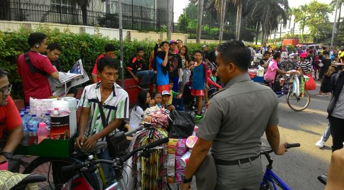 Petugas Satpol PP berusaha menertibkan PKL di CFD Jakarta, Minggu (10/1/2016). (Liputan6.com/Ahmad Romadoni)