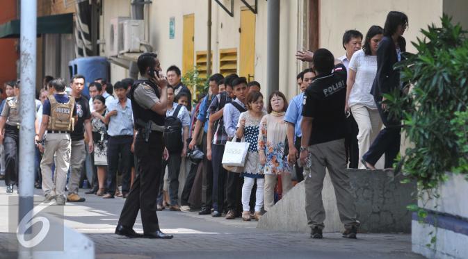 Sejumlah pekerja saat dievakuasi dari kantor mereka di Thamrin di Jakarta (14/1/2015). Beberapa ledakan dan suara senjata api terjadi di pusat ibukota Indonesia, Polisi mencurigai seorang melakukan aksi bom bunuh diri. (Liputan6.com/Gempur M Surya)