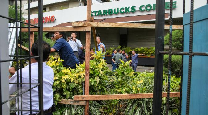 Seng-seng yang menutupi bagian depan gerai Starbucks, Jalan MH Thamrin, Jakarta, mulai dibongkar petugas, Jumat (15/1). Pasca-ledakan, pihak pengelola Menara Cakrawala memagari dengan seng, di sekeliling gedung. (Liputan6.com/Faizal Fanani)