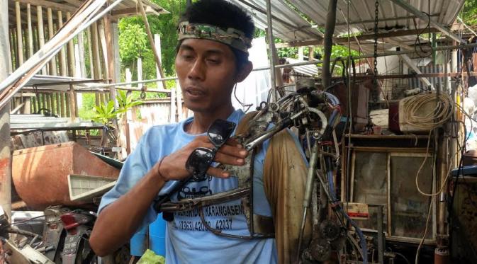 Manusia robot dari Bali menggerakkan tangan yang lumpuh dengan mesin. (Liputan6.com/Dewi Divianta)
